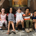 five children sitting at the door